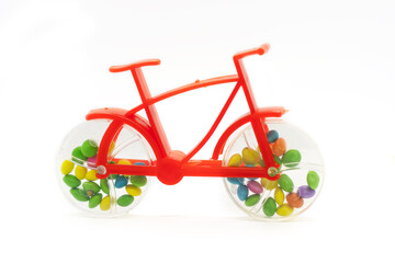 Plastic toy bicycle with chocolate nut candy inside the bicycle wheel