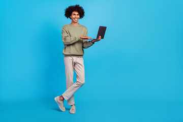 Full size photo of young man standing use laptop agent representative isolated over blue color background