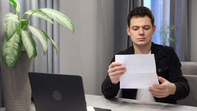 Sad man at home reads mail from university or college he was denied to admission