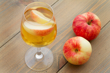 A glass of apple wine,cider, juice . Ripe summer apples are lying nearby