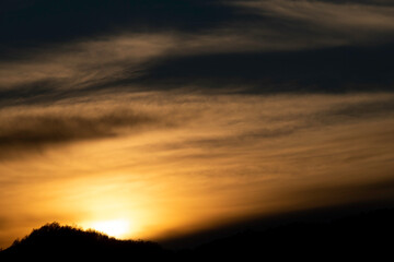 beautiful sunset of a fiery red with golden yellow hues with clouds reflecting these splendid colors of the sun