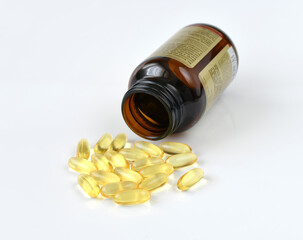 Gelatin capsules with omega-3 and glass bottle on a light background