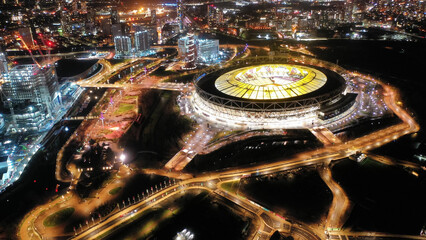 Aerial drone night shot of iconic illuminated London Stadium facilities in Queen Elizabeth Park,...