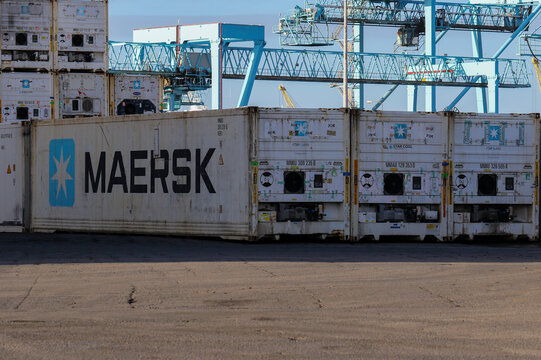 Maersk Shipping Containers Stacked In Port With Gantry Crane In Background. White Refrigerated Crates Used To Transport Or Ship Chilled Goods Or Freight. Ireland