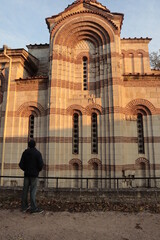 A male tourist examines an ancient, stone and beautiful temple.