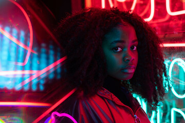 african girl and fringe looking at neon lights
