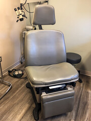 Medical Examination and Treatment Chair in the corner of a doctors office or clinic. - obrazy, fototapety, plakaty