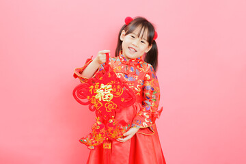 Chinese girl with traditional dressing up and holding a "Fu" means "lucky" greeting sign