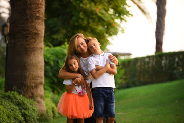 Fototapeta premium A happy mature mother with kids in the park