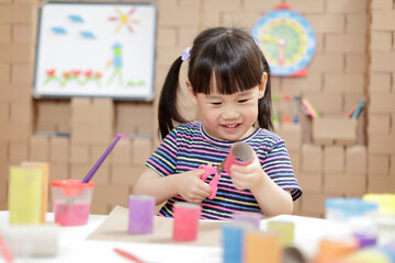 young girl making craft for homeschooling