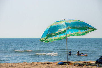 umbrella on a sandy beach with a cloudy sky, peaceful sea in background