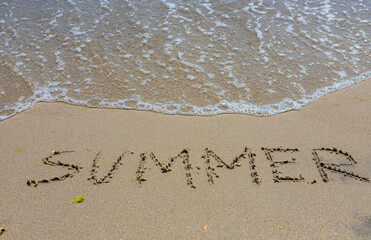 The inscription on the sand Summer symbolizes a summer vacation at the sea