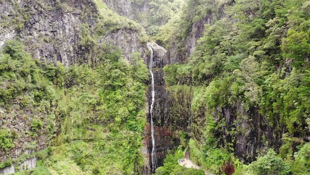 Aerial footage of spectacular jungle waterfall falling over sheer cliff.