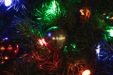 Gold ornament on a Christmas tree surrounded by lights