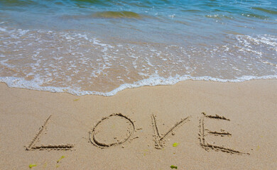 Inscription Love drawn on the sand. Concept of true and honest romantic feelings. spa novel on the sea