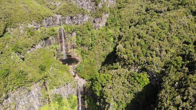 Aerial footage of spectacular jungle waterfall falling over sheer cliff.