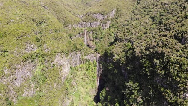 Aerial footage of spectacular jungle waterfall falling over sheer cliff.