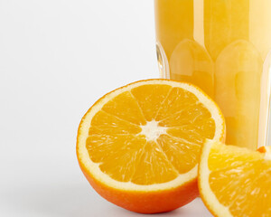 Sliced orange and a glass of orange juice on a white background. The glass is not fully visible