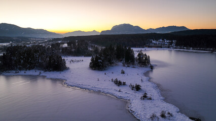 Wunderschöne Aufnahmen des zugefrorenen Faaker Sees + Insel in Österreich / Kärnten bei Sonnenuntergang - beautiful photograph of a frozen lake in Carinthia - Austria at sunset  -dji mavic 3 cine  4k 
