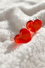 Close up couple of hearts on white fur background. Greeting concept for Valentines day, Mothers day, romantic data or wedding. Trendy sunlight still life.