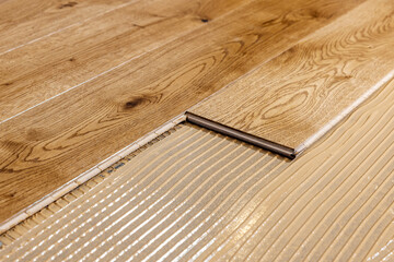 parquet floor installation. wooden planks on flooring glue - obrazy, fototapety, plakaty