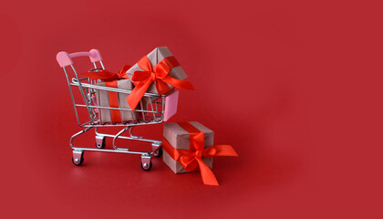 Mock up greeting banner for Valentines day sale.  Shopping cart with gifts  on red background. Minimalist mock concept for Christmas, Valentines day,  Mothers day, Women day or Black Friday sale.