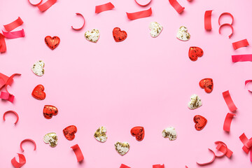 Frame made of serpentine and hearts on pink background
