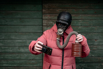 Woman with old gas mask takes a selfie with a mobile phone. Concept - Nuclear Disarmament and...