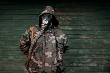 Woman with old gas mask and army jacket with a hood. Concept - Nuclear Disarmament and Radiation...