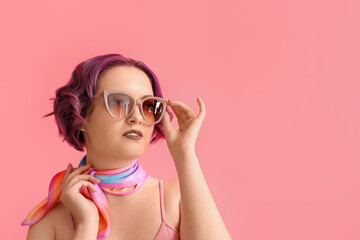 Beautiful young woman with violet hair on pink background. Very Peri - color of year 2022