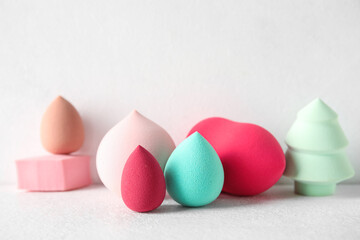 Different makeup sponges on light background, closeup