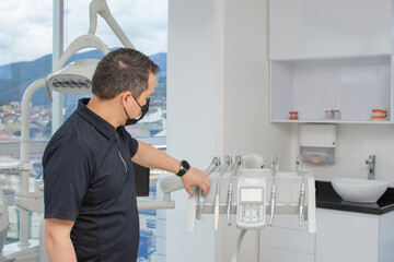 Dentist man preparing the clinical equipment for a consultation. Dental clinic concept