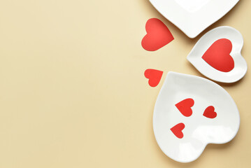 Beautiful heart-shaped plates on beige background