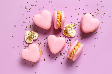 Tasty heart-shaped macaroons an confetti on purple background