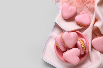 Plate with tasty heart-shaped macaroons on grey background