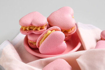 Plate with tasty heart-shaped macaroons on grey background, closeup