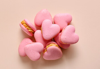 Obraz premium Tasty heart-shaped macaroons on beige background