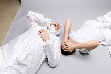 Two tired doctor male and female in a protective suit on the floor, exhausted in the fight against a pandemic covid-19