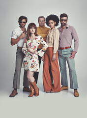 Nothing like some 70s style. A studio shot of a group of people standing together while clad in...