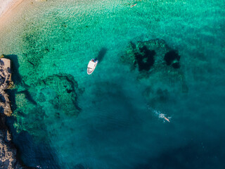 Fototapeta na wymiar Beach lubenice in the adriatic coast aerial view with one boat and swimmer