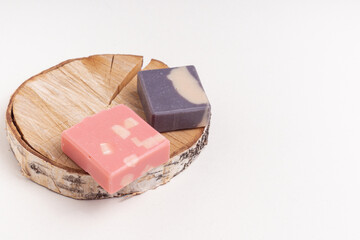 Handmade pink and brown soaps on wooden background. Natural soaps with orange and coffee smells. Space for text