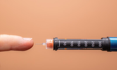insulin pen with needle in hand - obrazy, fototapety, plakaty