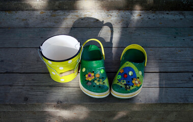 Green clogs on a wooden porch