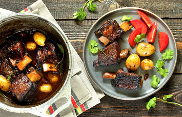 short ribs stew with new potatoes.
long stewed meat. serving with tomatoes and herbs