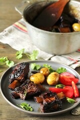 short ribs stew with new potatoes.
long stewed meat. serving with tomatoes and herbs