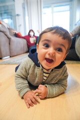 baby crawling at home with his mother in the background in the living room of his home