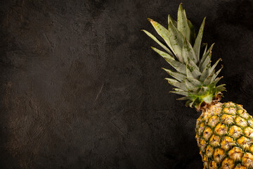 Whole pineapple on dark background.