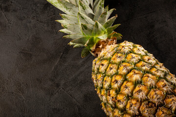 Whole pineapple on dark background.