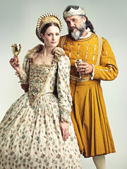 This is how we royals roll. Studio portrait of a king and queen drinking out of goblets.