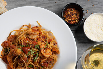 Spicy spaghetti with shrimps and seafood in tomato sauce